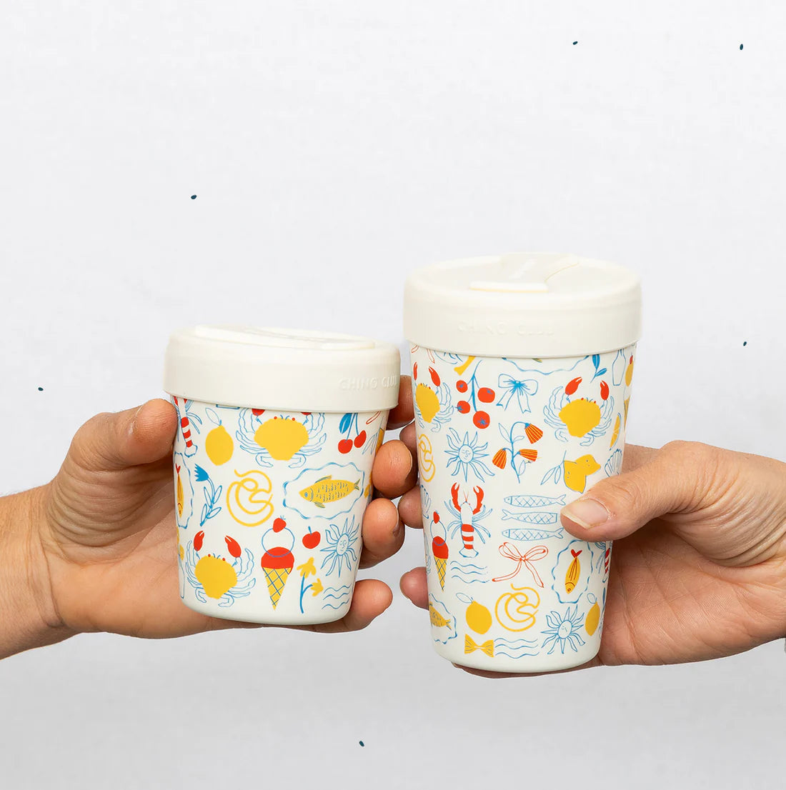 Two hands holding ice cream cups with colorful patterns on a white background