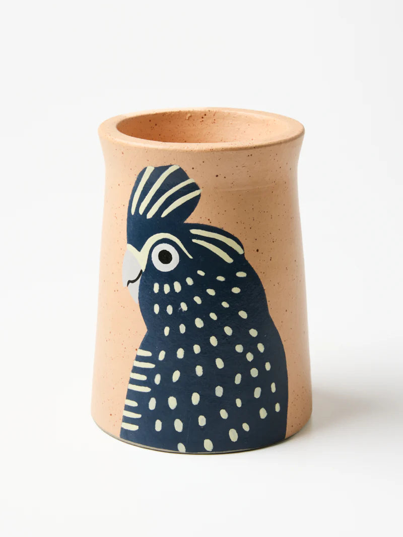 Ceramic cup with a blue and white bird design on a beige background