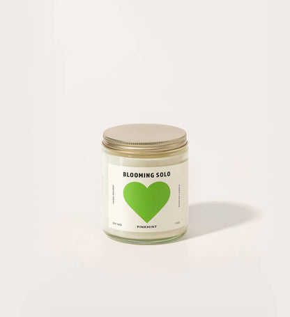 Candle jar with a green heart label on a white background