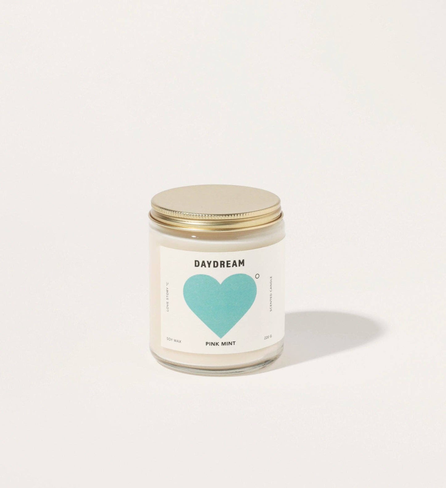 Candle jar with a heart-shaped label on a white background