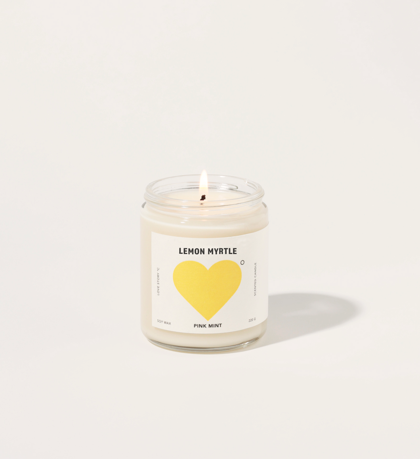 Candle in a jar with a heart-shaped label on a white background and words lemon myrtle.