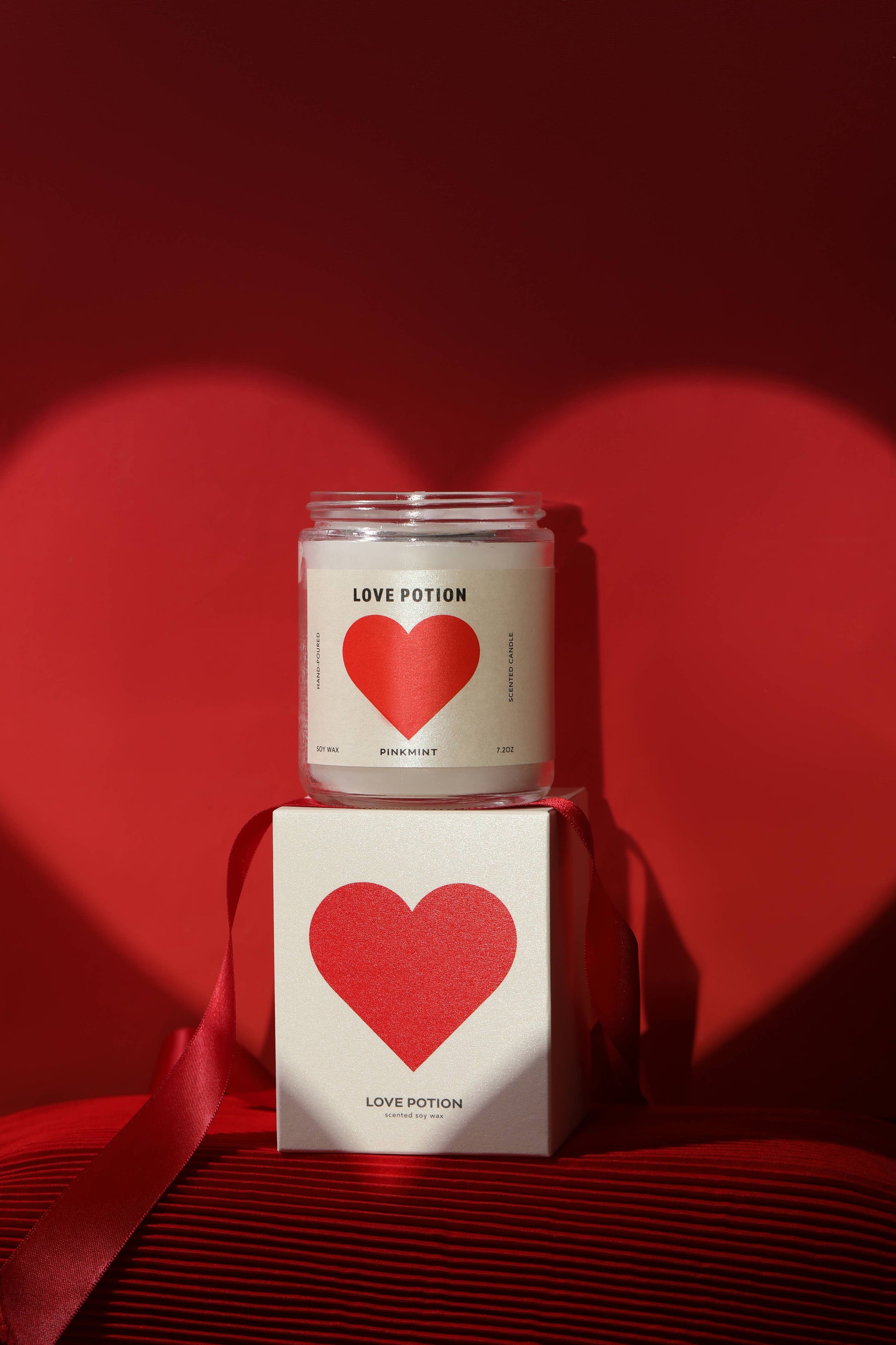 Candle labeled 'Love Potion' with a matching box on a red background