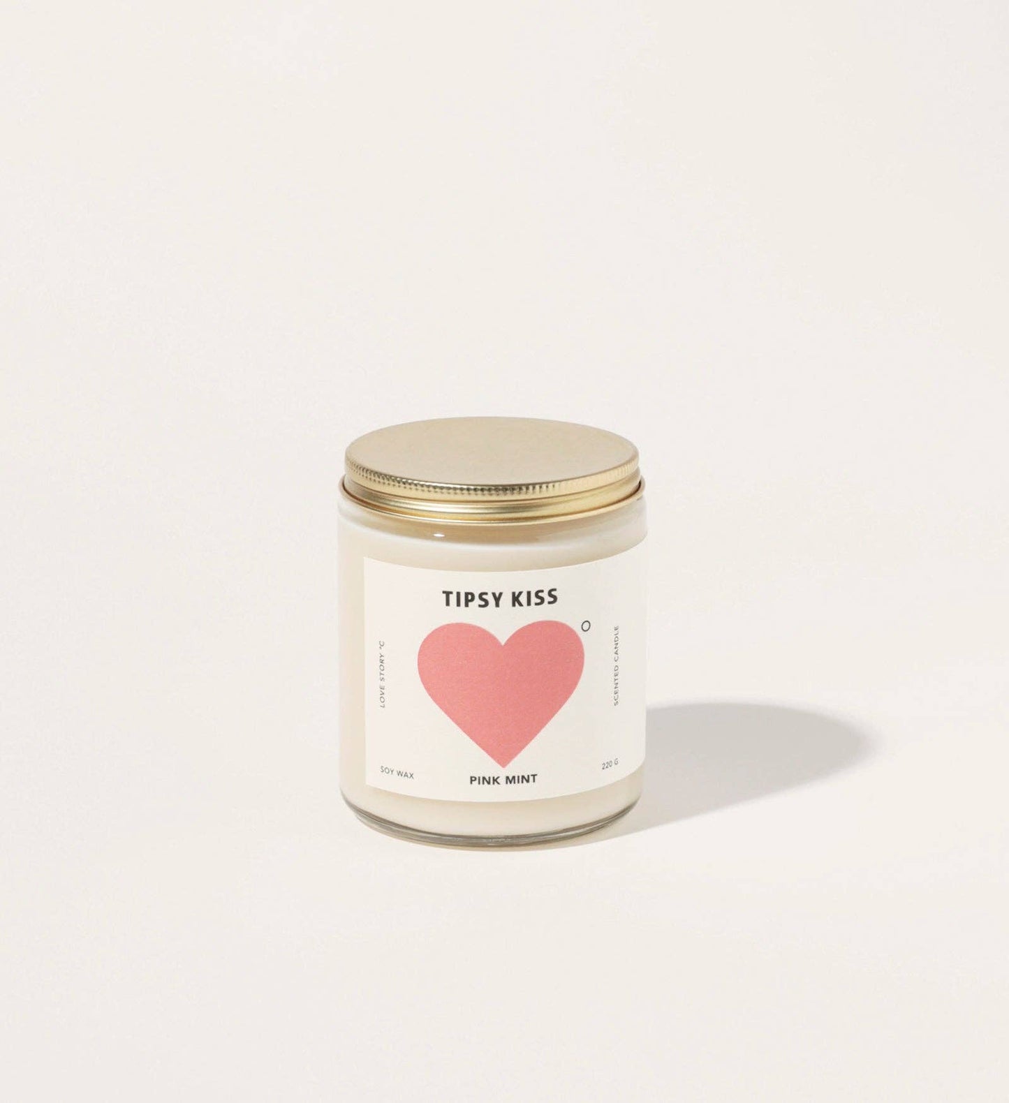Candle with a heart design and 'Tipsy Kiss' label on a white background